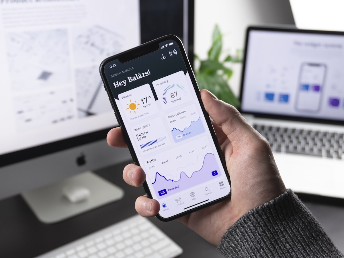 Person holding iPhone — App Store and Google Play submission